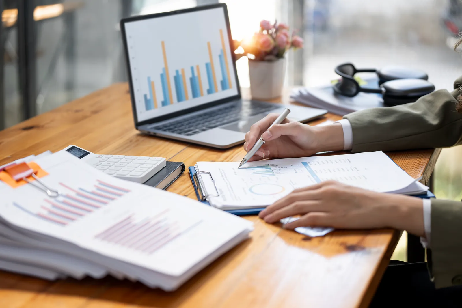 Comptable annotant un rapport devant un graphique sur ordinateur portable