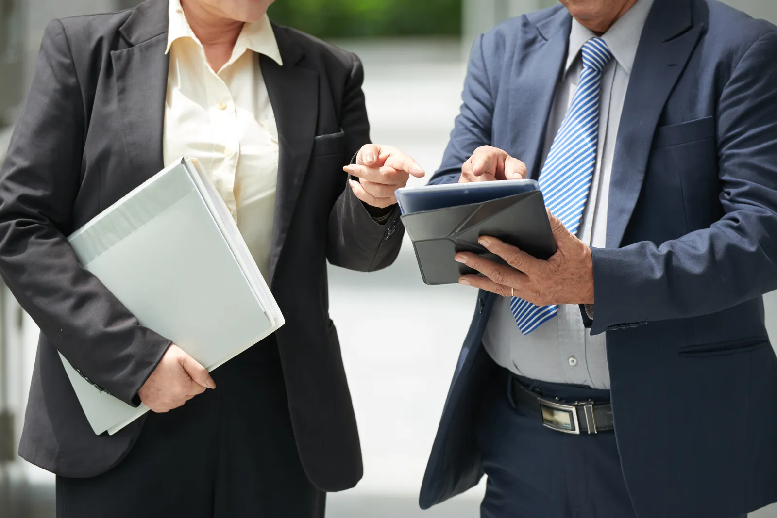 Deux dirigeants consultant une tablette et un dossier